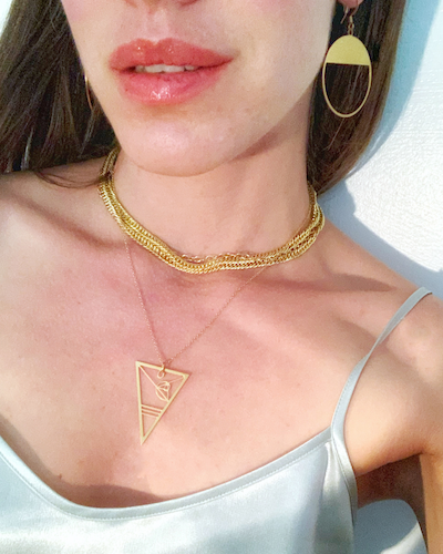 Model wears a silver skinny strap top, the Rael Cohen Fibonacci Necklace, and Rael Cohen gold drop earrings.